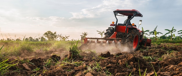 Fazendeiro com trator prepara o terreno para o cultivo agrícola.