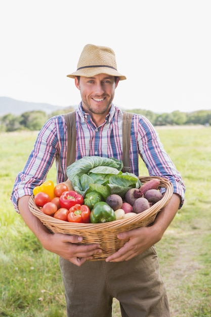 Fazendeiro que transporta a caixa de vegetais