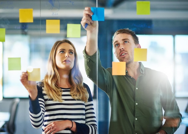 Fazendo as perguntas certas para obter as respostas certas Foto de colegas tendo uma sessão de brainstorming com notas adesivas no trabalho