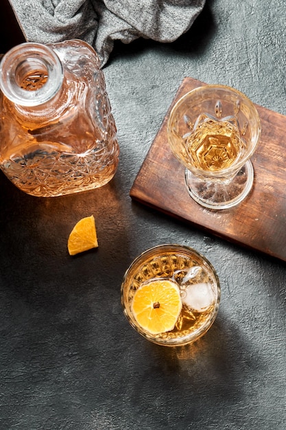 fazendo bebida com uísque de laranja e mel, coquetel com frutas na base preta rústica