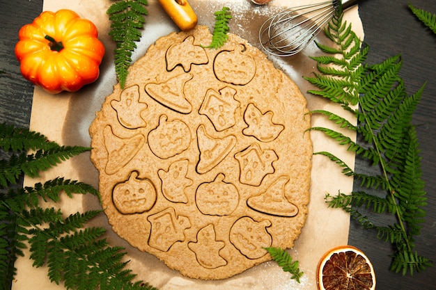 Fazendo biscoitos caseiros de gengibre. símbolos de halloween - abóbora, chapéu, fantasma. fundo de comida de outono.