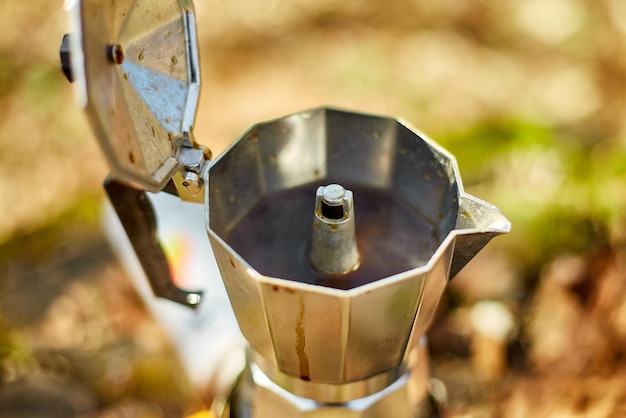 Fazendo café de acampamento de uma cafeteira gêiser em um queimador a gás