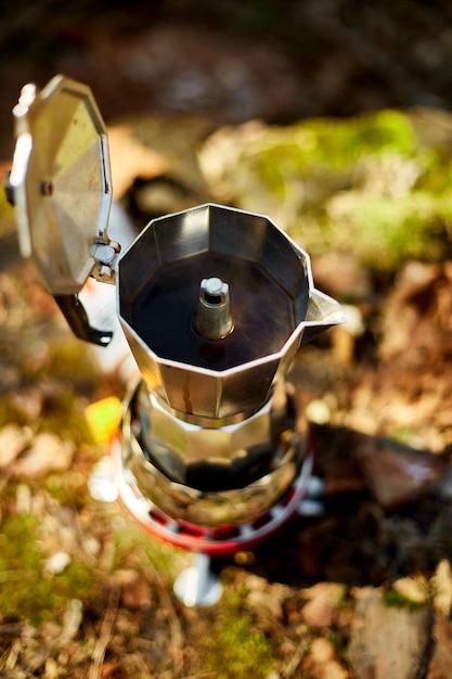 Fazendo café de acampamento de uma cafeteira gêiser em um queimador a gás