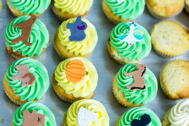 Fazendo cupcakes multicoloridos para festa de aniversário de crianças.