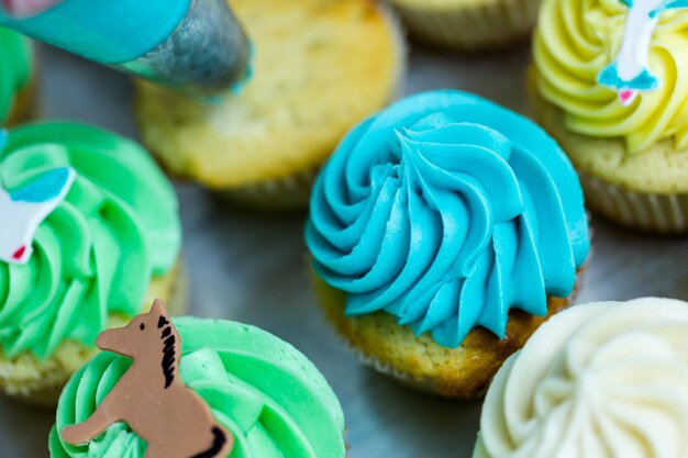 Fazendo cupcakes multicoloridos para festa de aniversário de crianças.