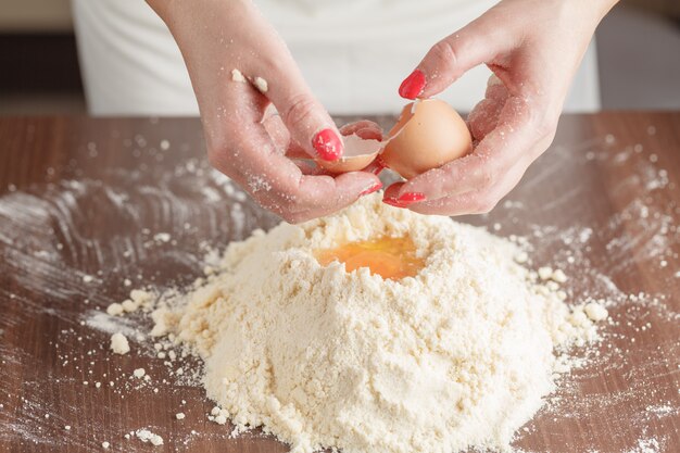 Fazendo massa de pastelaria para bolo húngaro. Series. Um padeiro misturando farinha, creme de leite e ovos