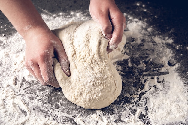 Fazendo massa por mãos femininas na padaria, produção de produtos de farinha