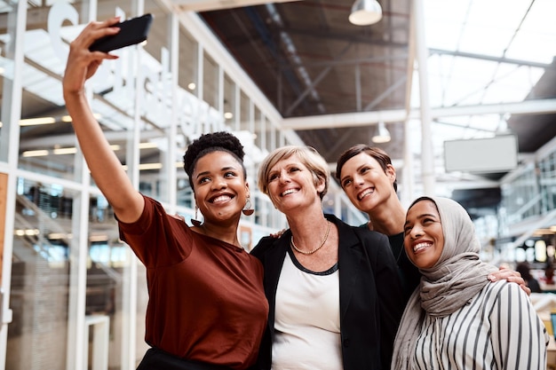 Fazendo memórias como colegas próximos Retrato de um grupo de empresárias tirando selfies juntas em um escritório