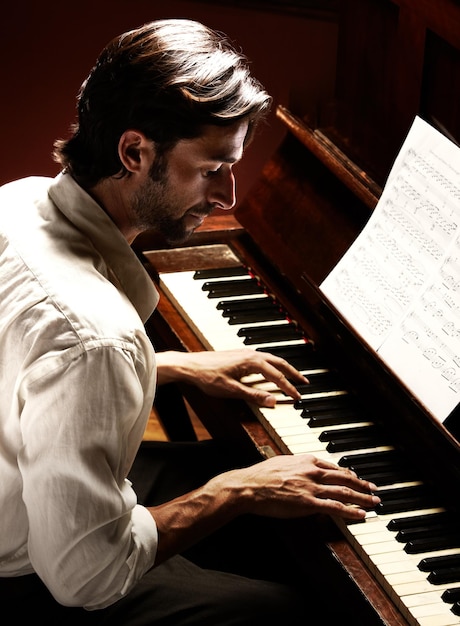 Fazendo música bonita Perfil de um homem bonito tocando piano