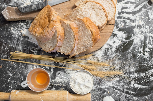 Fazendo o pão no estilo rústico, tipos diferentes de rolos de pão na tabela de madeira. Design de padaria de cozinha.