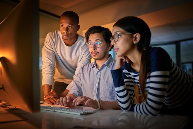 Fazendo o trabalho em conjunto Foto de programadores de computador trabalhando juntos até tarde no escritório