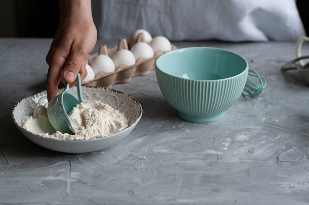 Fazendo panquecas com o chef. Chef em seu local de trabalho com inventário de cozinha e ingredientes em um escuro