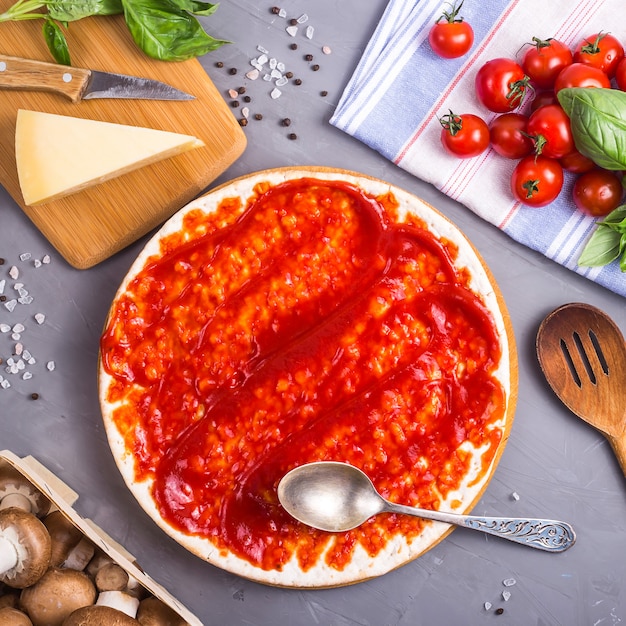 Fazendo pizza caseira de massa com cogumelos, tomate e queijo