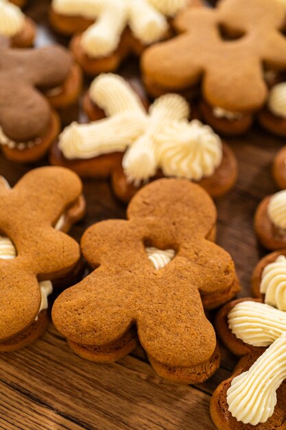 Fazendo sanduíches de pão de gengibre festivo em uma mesa de madeira rústica