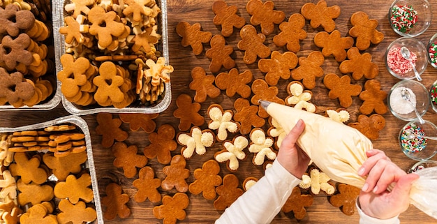 Fazendo sanduíches de pão de gengibre festivo em uma mesa de madeira rústica