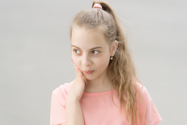 Fazendo seu cabelo parecer brilhante. Adorável menina com longos cabelos loiros. Criança pequena bonita com estilo de cabelo de rabo de cavalo. Manter o cabelo saudável.