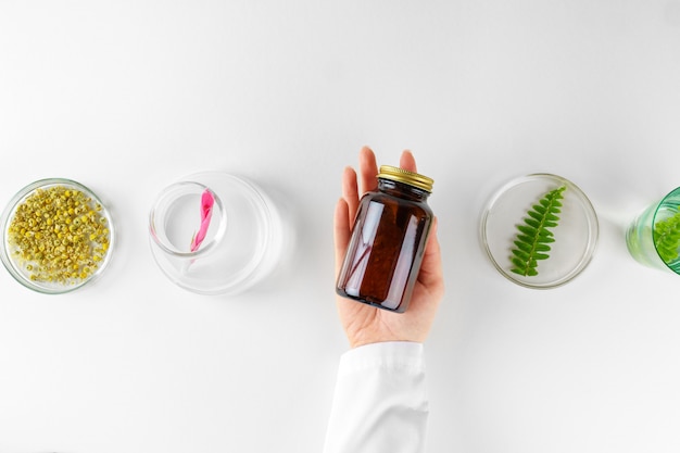 Fazendo suplemento dietético à base de plantas em laboratório com folhas de plantas. Conceito de saúde e beleza