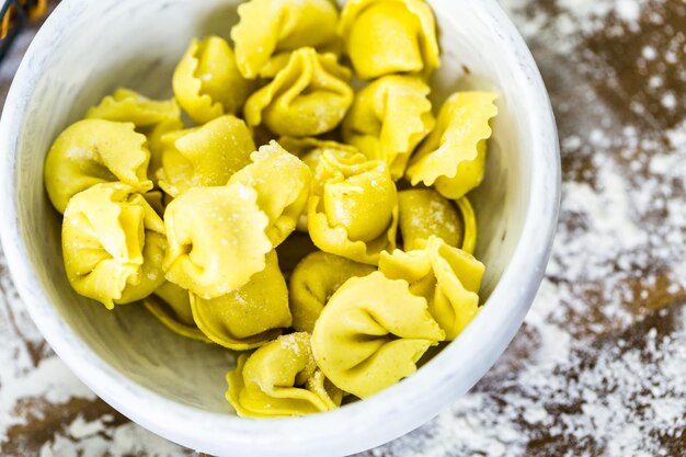 Fazendo tortellini de quatro queijo caseiro com produtos frescos da fazenda.