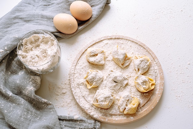 Fazendo tortellini em casa, feito à mão, na bancada da cozinha