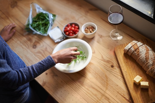 Fazendo um lanche saudável Uma jovem fazendo uma salada em sua cozinha