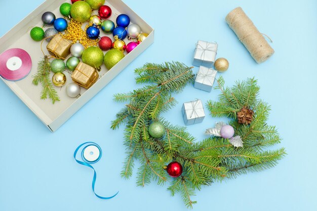 Fazendo uma guirlanda de Natal Bolas de Natal fita e caixas Fundo azul