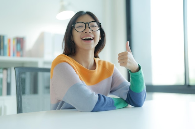 Fazendo uma pausa de estudar na biblioteca é uma jovem sorridente ou estudante usando óculos