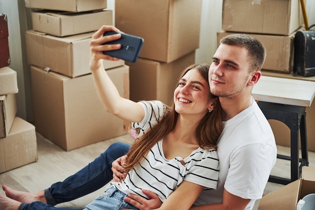 Fazendo uma selfie. Casal jovem alegre em seu novo apartamento. Concepção de movimento.