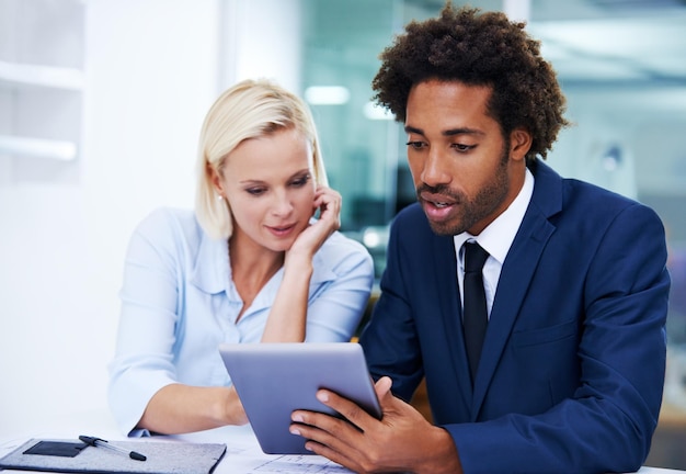 Foto fazendo uso da tecnologia para maximizar a eficiência foto de um colega masculino e feminino discutindo algo em um tablet digital