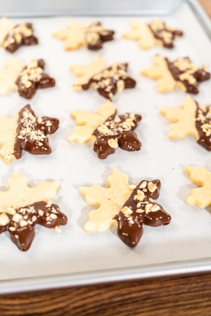 Fazer biscoitos de açúcar com ponta de chocolate e avelãs.