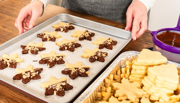 Fazer biscoitos de açúcar com ponta de chocolate e avelãs.