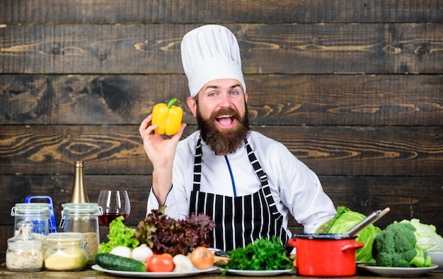 Fazer dieta alimentos orgânicos Cozinhar comida saudável Hipster maduro com barba Cozinha culinária Vitamina Salada vegetariana com legumes frescos Receita de chef de homem barbudo feliz Legumes picados