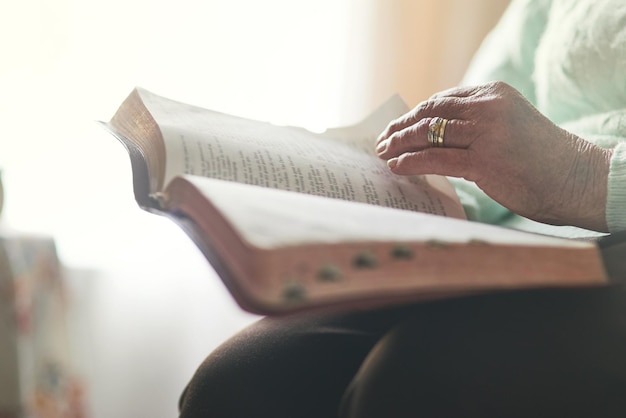 La fe es lo primero Primer plano de una mujer irreconocible leyendo una biblia