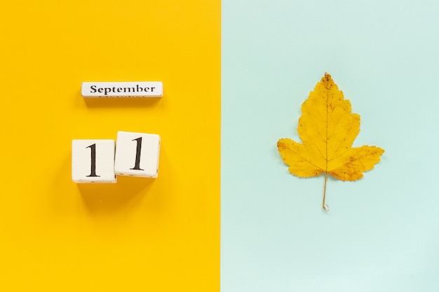 Foto fecha del calendario y hoja amarilla de otoño