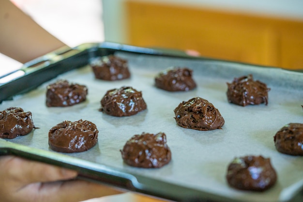 Foto fechado de cookies de brownie na assadeira, preparando-se para assar.