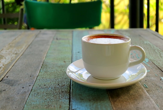 Fechado uma xícara de café Cappuccino quente servido na mesa de madeira de estilo rústico