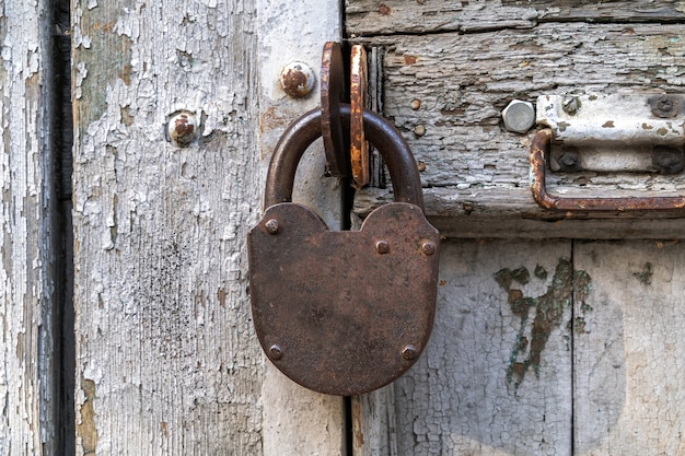 Foto fechadura de porta de aço velha em uma porta velha e danificada, close-up.