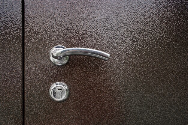 Fechadura de porta típica. maçaneta. uma fechadura metálica com maçaneta em uma porta de metal marrom.