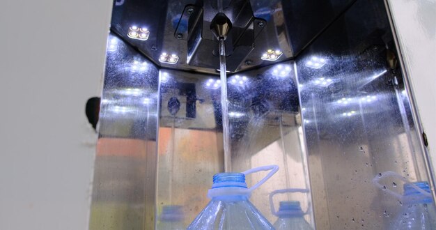 Foto fechamento de água com garrafa de água de plástico de 5 litros na estação local de filtragem de água com máquina de filtro de água de sistema automático