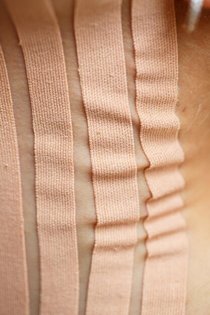 Fechamento de uma fita no pescoço de uma jovem Cinesioterapia com fitas terapêuticas