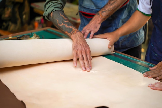 Fechamento e corte das mãos do artesão de couro tocando na falha do couro branco