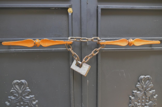 Fechamento enferrujado velho fechado em uma porta de madeira