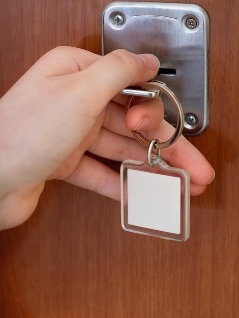 Fechando a porta da casa por chave com chaveiro em branco
