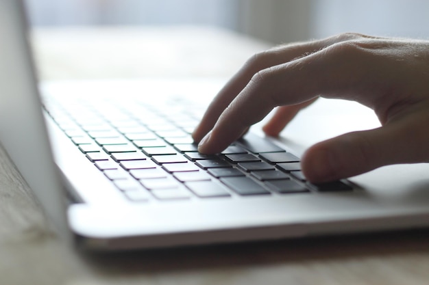 Fechar a mão de um empresário pressionando o botão no teclado do laptop