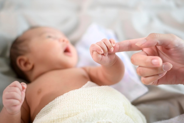 Fechar a mão segurando o dedo do bebê recém-nascido