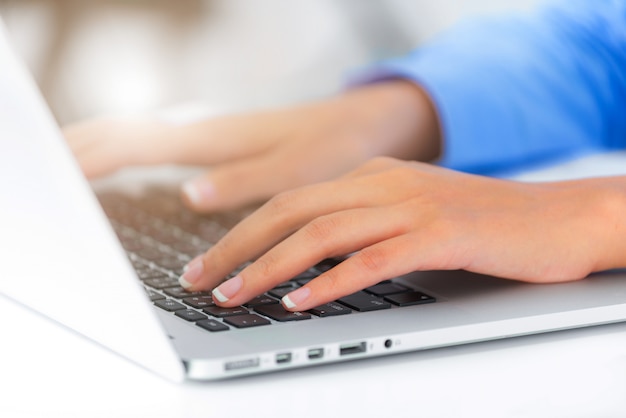 Fechar as mãos da empresária digitando no teclado do laptop