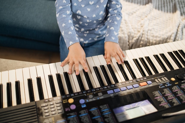 Fechar as mãos de pequenas teclas femininas e de piano