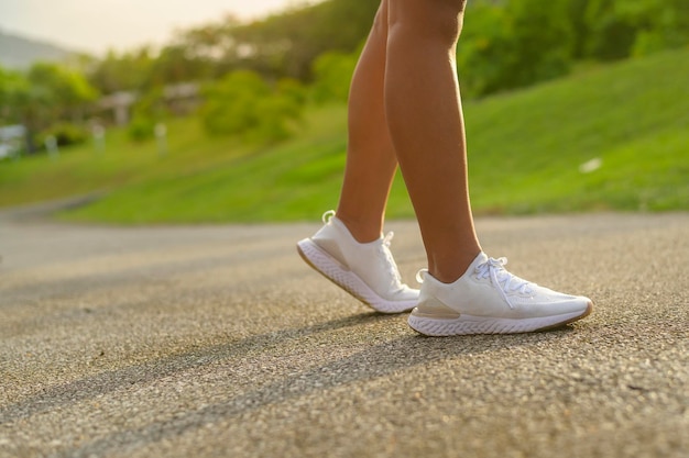 Fechar as pernas da mulher desportiva em sapatos de corrida Conceito de saúde e desporto