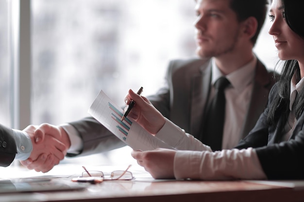 Fechar empresários de aperto de mão de negócios no conceito de negócios de mesa