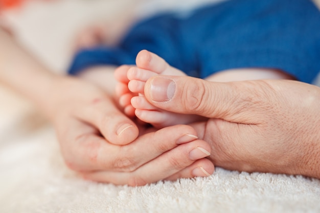 Fechar foto de um pé de bebê nas mãos da mãe