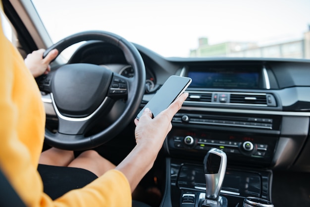 Fechar imagem com motorista do sexo feminino e tela do telefone em branco